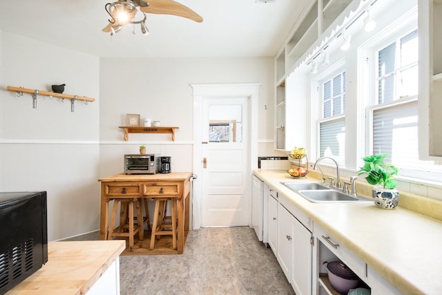 kitchen with white cabinetry, open shelves, and a sink