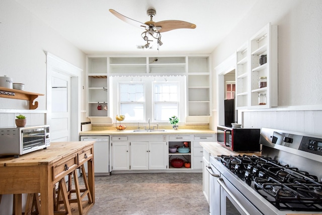 kitchen with open shelves, a toaster, dishwasher, stainless steel gas stove, and a sink