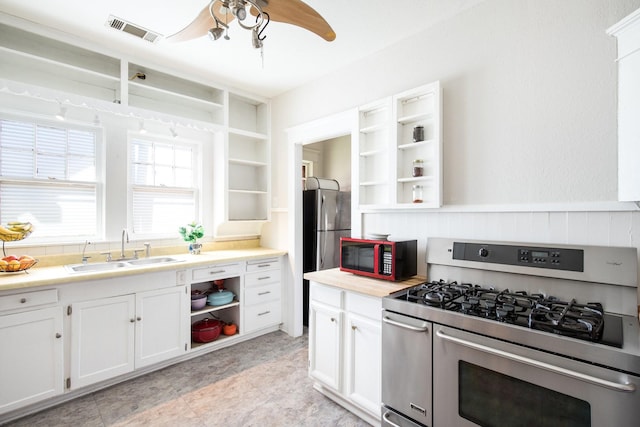 kitchen with open shelves, visible vents, appliances with stainless steel finishes, and a sink