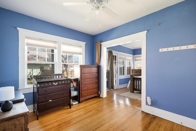 living area with wood finished floors, baseboards, a wealth of natural light, and ceiling fan