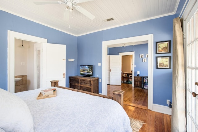 bedroom with baseboards, wood finished floors, visible vents, and ornamental molding