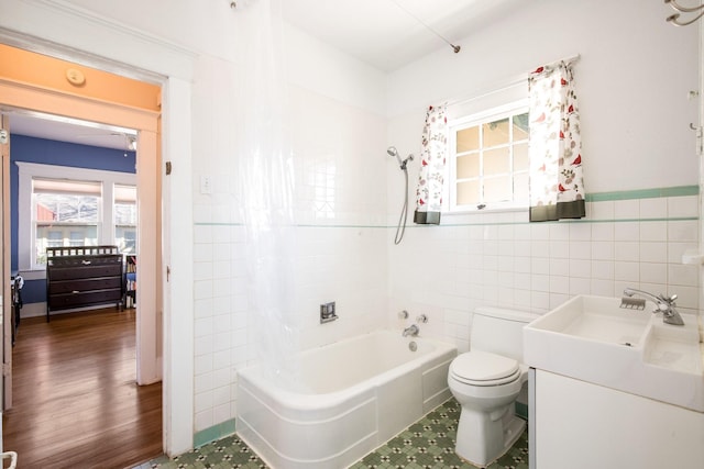 full bath with vanity, tile walls, shower / bath combination with curtain, and toilet