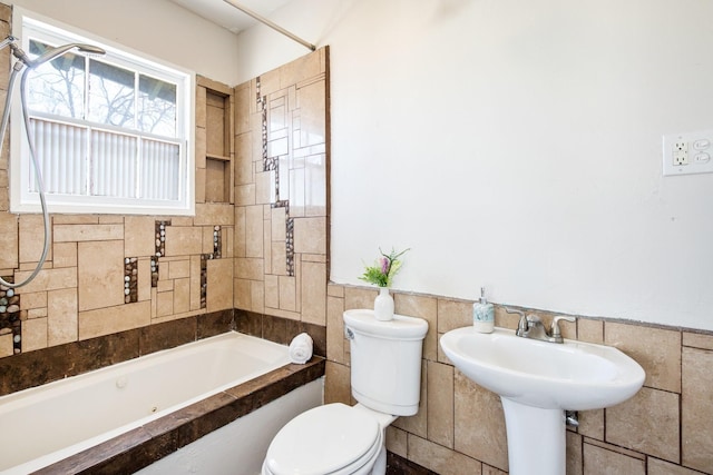 bathroom featuring a wainscoted wall, toilet, and tile walls