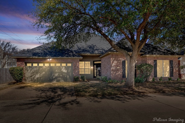 view of front of property with driveway, brick siding, and an attached garage