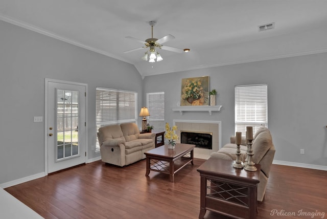 living room featuring ceiling fan, wood finished floors, visible vents, and a tile fireplace