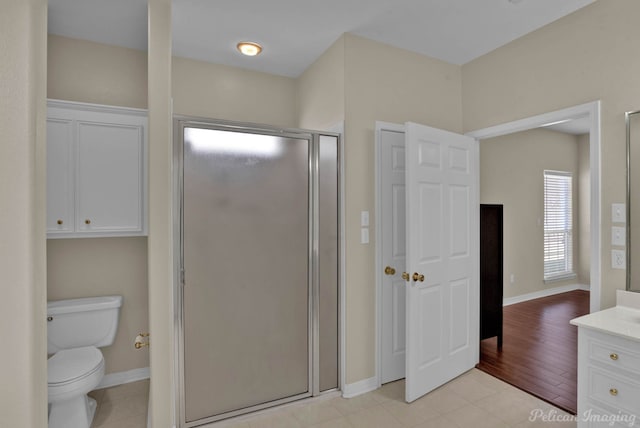 bathroom featuring baseboards, toilet, a stall shower, and vanity