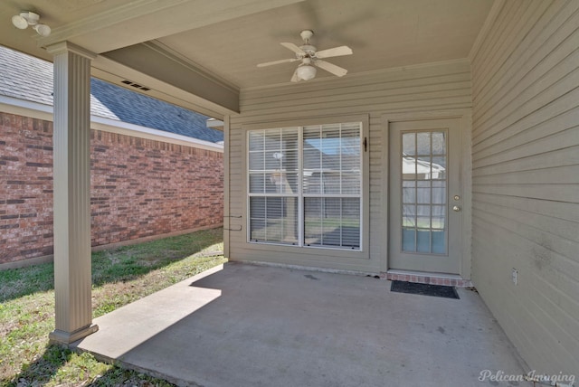 entrance to property with brick siding, roof with shingles, a ceiling fan, and a patio area