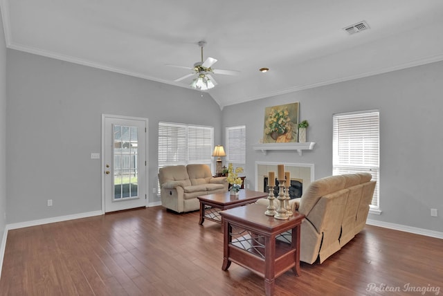 living room with a wealth of natural light, visible vents, a fireplace, and dark wood-style flooring