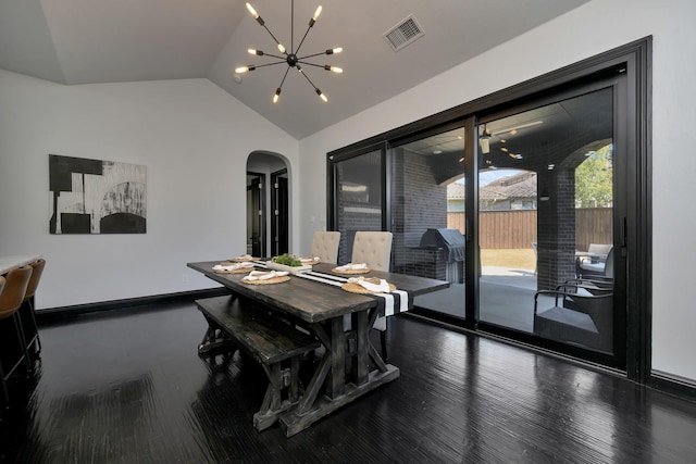 dining room featuring visible vents, arched walkways, lofted ceiling, wood finished floors, and an inviting chandelier