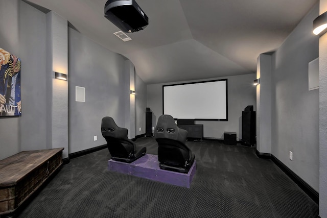 carpeted cinema room with lofted ceiling, baseboards, and visible vents