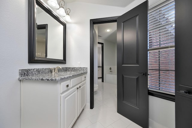 bathroom featuring visible vents, toilet, tile patterned floors, a bathtub, and vanity