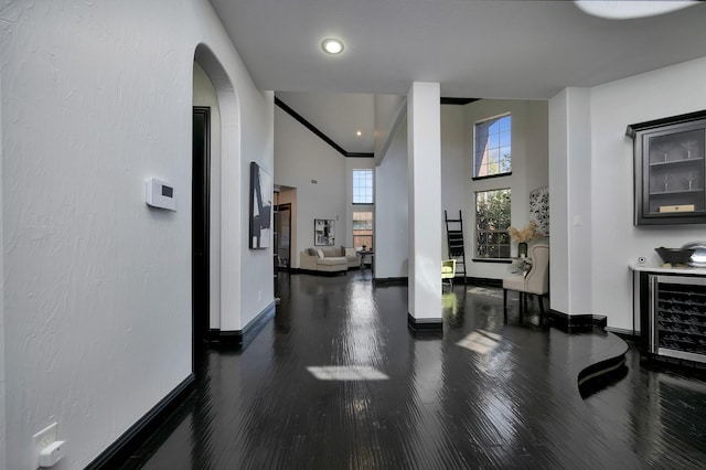 hall featuring beverage cooler, baseboards, and wood finished floors