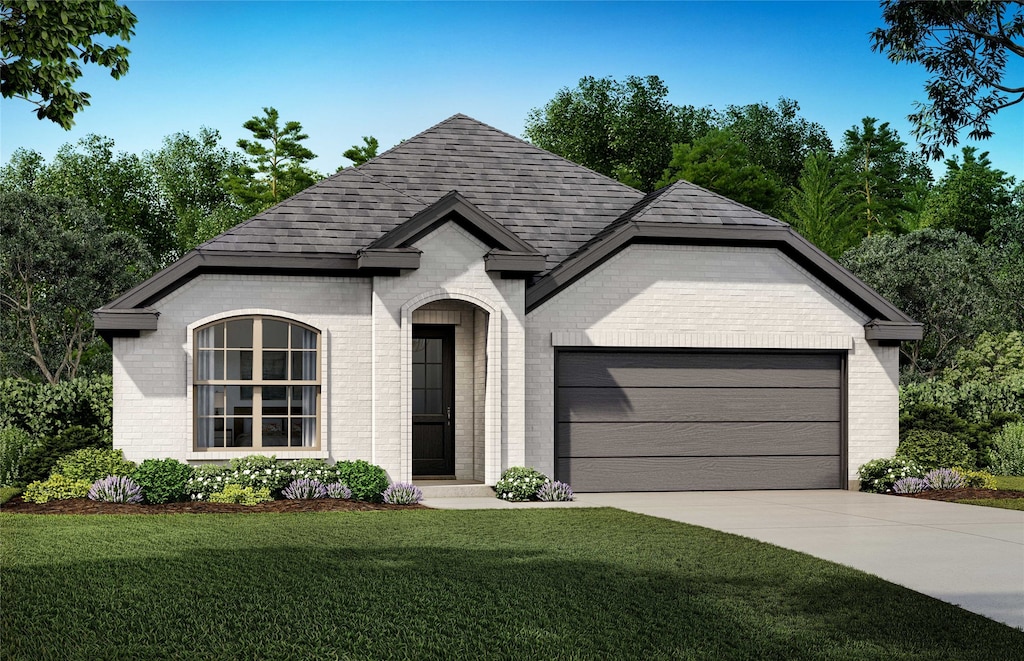 french country style house with a garage, brick siding, a shingled roof, concrete driveway, and a front yard