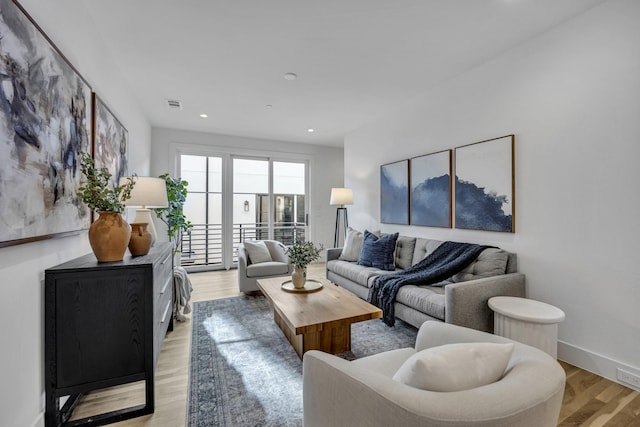 living room with light wood finished floors, baseboards, visible vents, and recessed lighting