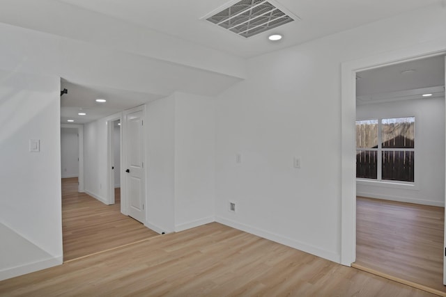 unfurnished room featuring light wood-style floors, recessed lighting, visible vents, and baseboards