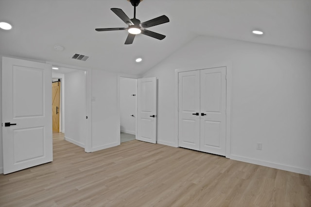 unfurnished bedroom featuring ceiling fan, lofted ceiling, visible vents, baseboards, and light wood-style floors