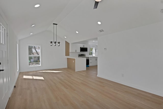 unfurnished living room featuring lofted ceiling, a wealth of natural light, visible vents, and light wood-style floors