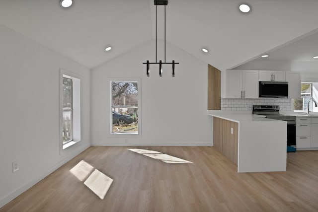 kitchen featuring white cabinetry, vaulted ceiling, light countertops, stainless steel electric range oven, and tasteful backsplash