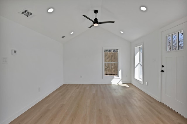 interior space featuring lofted ceiling, light wood finished floors, visible vents, and baseboards