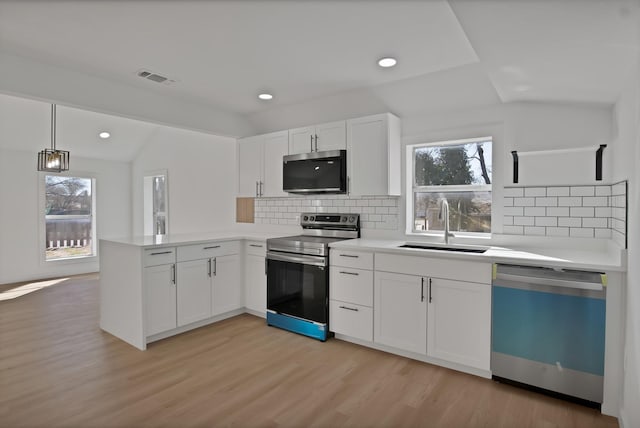 kitchen featuring stainless steel electric stove, lofted ceiling, visible vents, a peninsula, and dishwashing machine