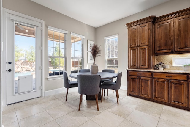 dining space featuring light tile patterned floors and baseboards