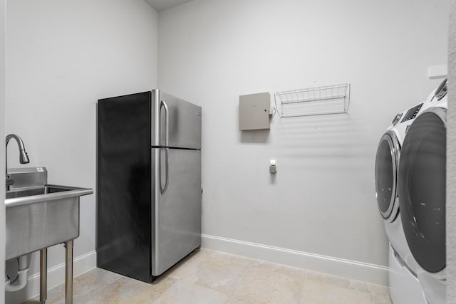 laundry area featuring laundry area, washer and clothes dryer, and baseboards