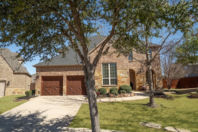 view of front of property featuring driveway, brick siding, stone siding, an outdoor structure, and a front yard