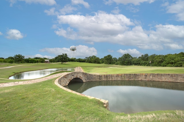 view of home's community with a water view, golf course view, and a lawn