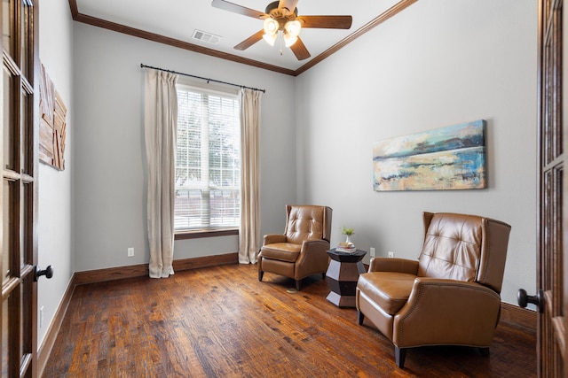 living area with wood finished floors, a ceiling fan, baseboards, visible vents, and crown molding