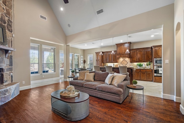 living area featuring visible vents, a fireplace, and light wood-style flooring