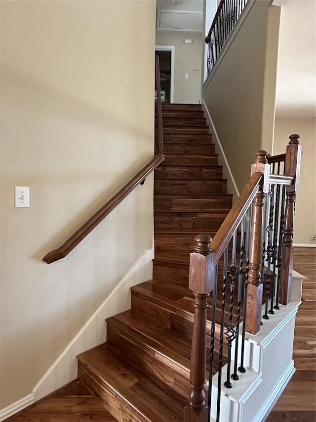 staircase with baseboards and wood finished floors