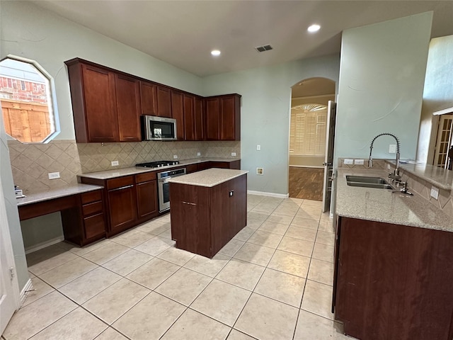 kitchen featuring visible vents, backsplash, light tile patterned floors, stainless steel appliances, and a sink