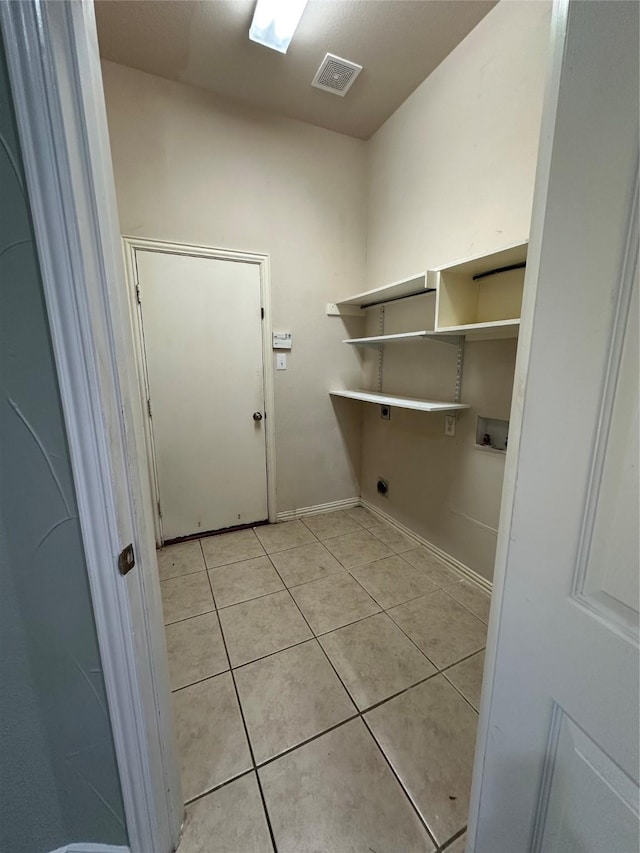 clothes washing area with visible vents, hookup for an electric dryer, laundry area, light tile patterned flooring, and washer hookup