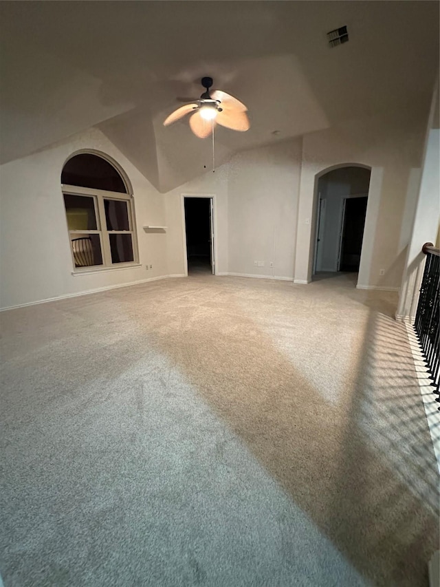 unfurnished living room with visible vents, built in shelves, arched walkways, baseboards, and light colored carpet