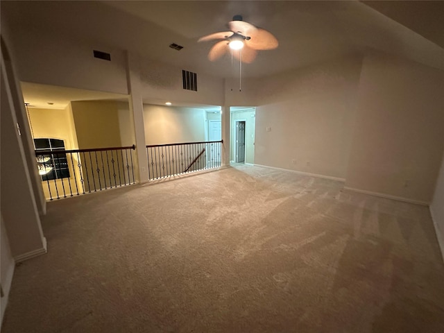 empty room with carpet, visible vents, and baseboards