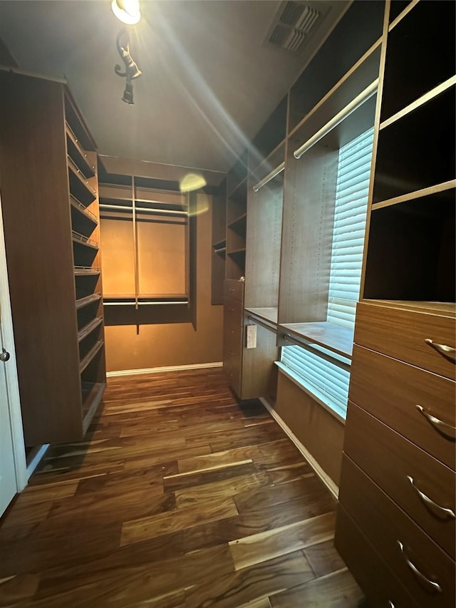 walk in closet featuring vaulted ceiling, visible vents, and wood finished floors