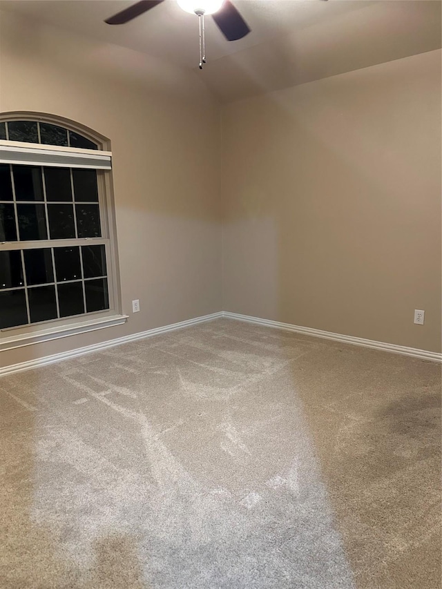 carpeted spare room with baseboards and ceiling fan