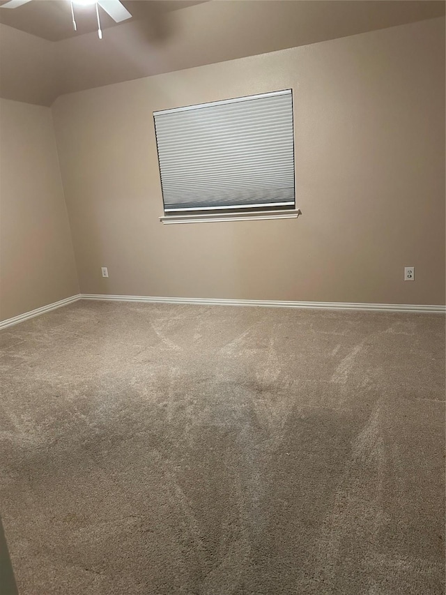 carpeted empty room with baseboards and a ceiling fan