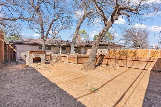 exterior space with brick siding, fence, and a chimney