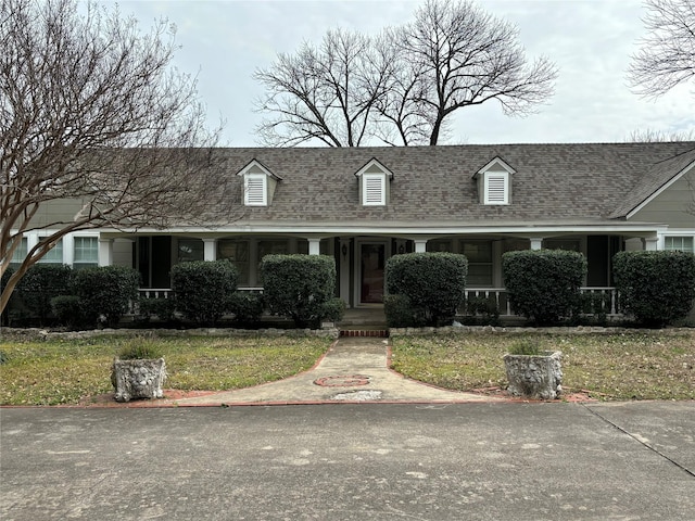 cape cod house with a shingled roof and a porch