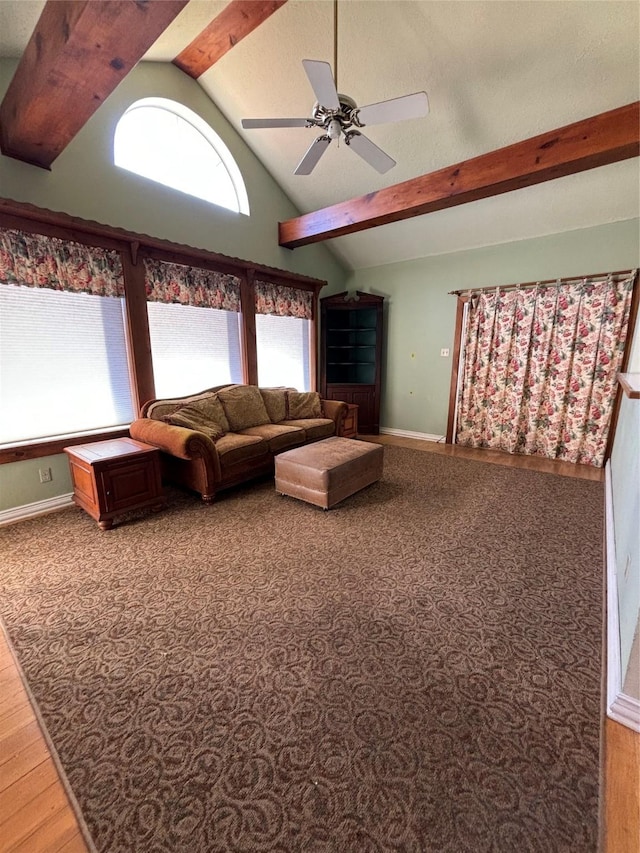 living area with ceiling fan, high vaulted ceiling, beam ceiling, and baseboards