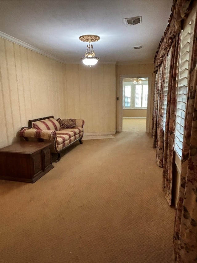 unfurnished living room featuring crown molding, visible vents, and carpet flooring