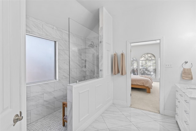 ensuite bathroom with baseboards, connected bathroom, marble finish floor, walk in shower, and vanity