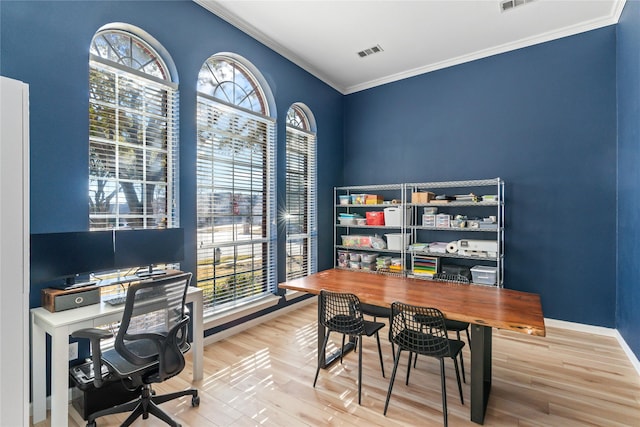 office featuring ornamental molding, a wealth of natural light, visible vents, and wood finished floors