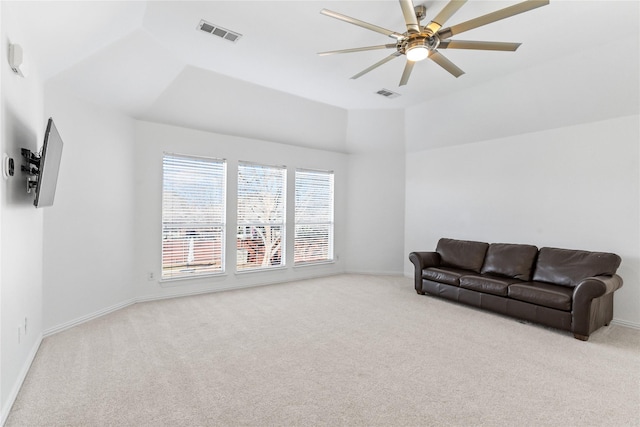 carpeted living room with baseboards, visible vents, vaulted ceiling, and a ceiling fan