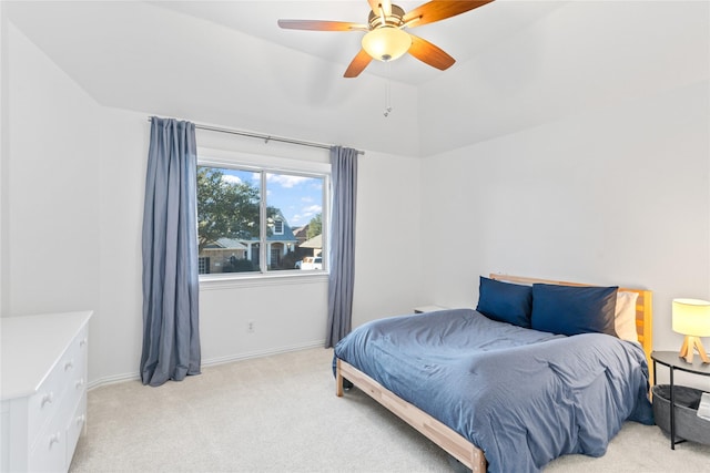 bedroom with light carpet, ceiling fan, vaulted ceiling, and baseboards