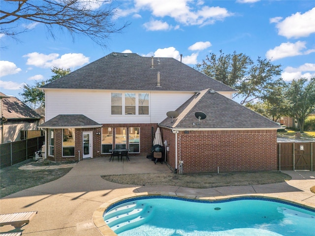 back of house featuring a patio area, a fenced backyard, a fenced in pool, and brick siding