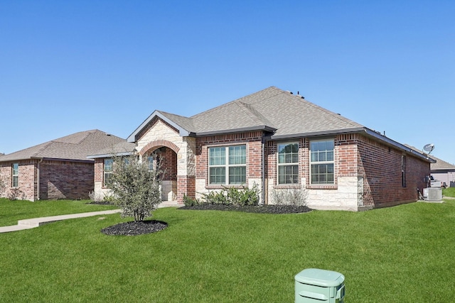 view of front of property featuring stone siding, brick siding, roof with shingles, and a front yard