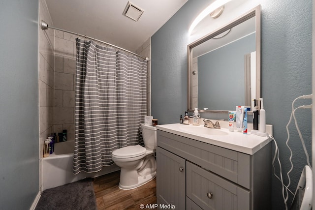 bathroom with toilet, shower / tub combo, wood finished floors, visible vents, and vanity