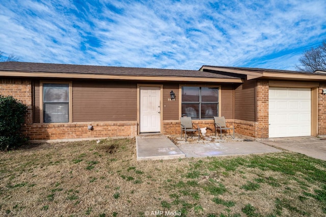 view of front of property featuring a garage, brick siding, and a front yard